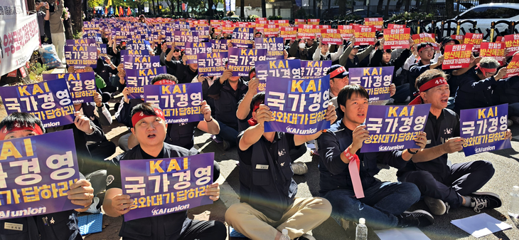 한국항공우주산업(KAI) 노동조합원들이 13일 청와대 사랑채 앞에서 한화그룹의 인수 시도를 반대하는 집회 현장에서 유인물을 들어보이고 있다. 사진=