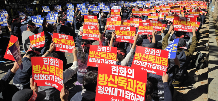 한국항공우주산업(KAI) 노동조합원들이 13일 청와대 사랑채 앞에서 한화그룹의 인수 시도를 반대하는 집회 현장에서 유인물을 들어보이고 있다. 사진=