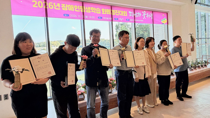 지난 12일 여주시 무이숲카페에서 열린 2026년 장애인 화훼경진대회 '피어라, 꽃처럼'에서 수상자들이 상장과 트로피를 들고 기념촬영을 하고 있다.
