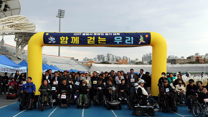 지난 15일 평택 소사벌레포츠타운에서 열린 '2026 평택시 장애인 걷기 대회(한마음체육대회)'에서 장애인 참가자들과 관계자들이 출발에 앞서 기념촬