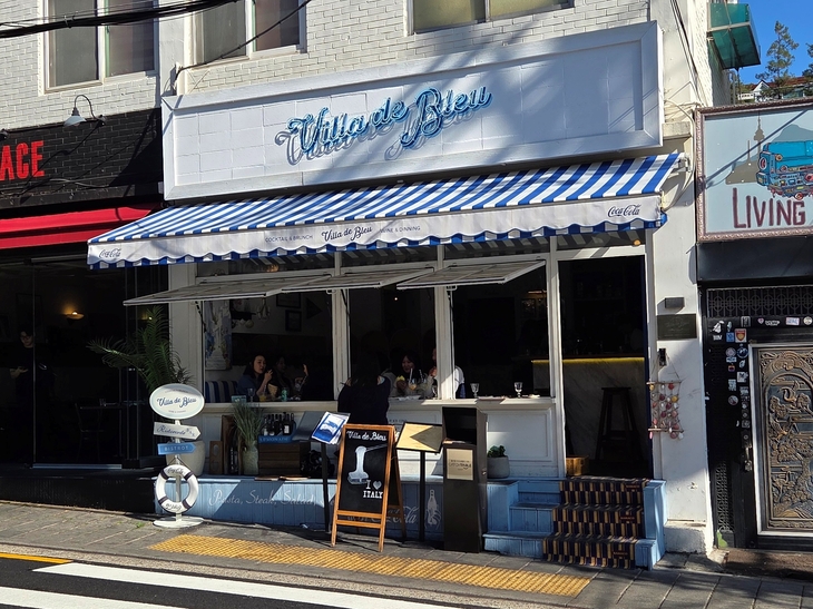 빌라드블루 전경. 가게 왼쪽에 '레스토랑·바·비스트로' 화살표 표지판 아래 코카콜라 구명튜브를 단 이정표가 있다. 사진=송민규 기자